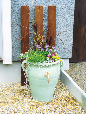 オープンテラスの一角におしゃれな立水栓を造りました。インターネットで購入した壷に塗装をほどこし、穴をあけて水栓を通しました。中には土を入れてかわいい花ポットとしてお庭のアクセントになっています。>