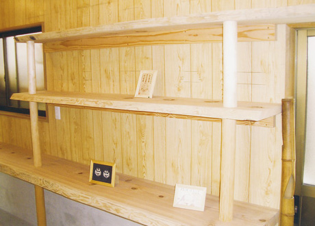 隣接する部屋には備前焼の窯があるので、作品を展示できるスペースも確保しました。棚には耳つきの杉板（赤目板）を使いました。>