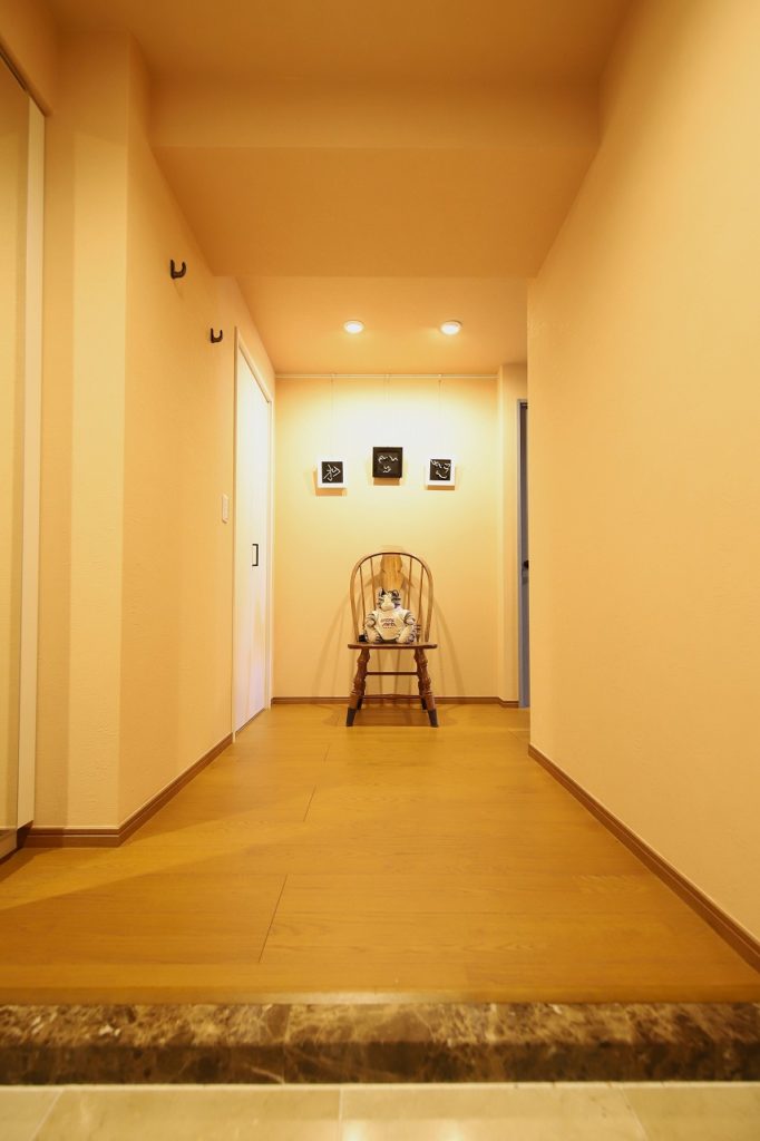 土壁調のクロスを貼った玄関ホールには奥様の作品と、ご主人からプレゼントされたぬいぐるみでお友達をお出迎え<br />
>