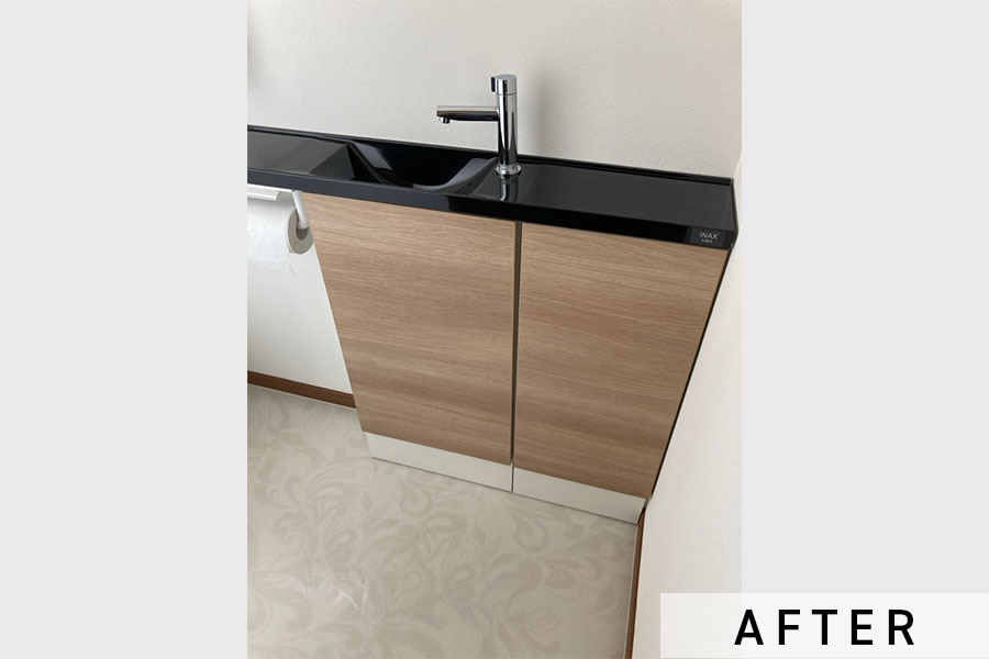 施工後のトイレ正面。手洗い場や奥行きの浅い収納棚があって便利です。>