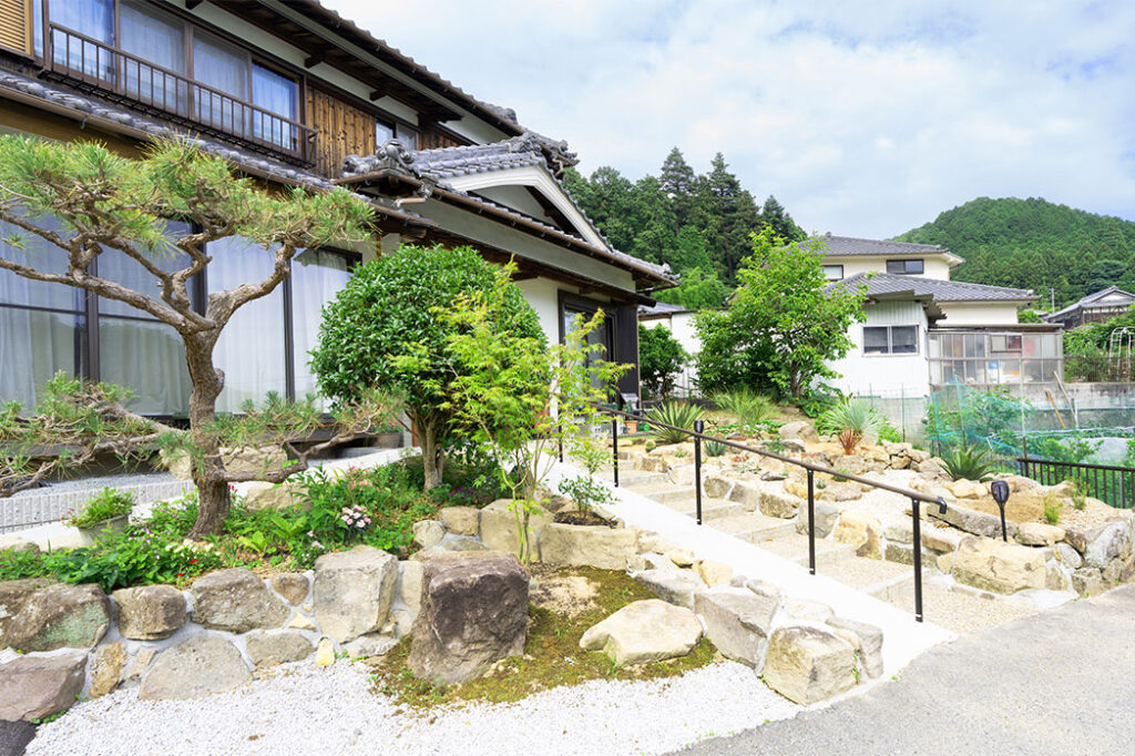 階段とスロープのダブルアプローチ。立派な石は元々お庭にあったものを再利用しました。>