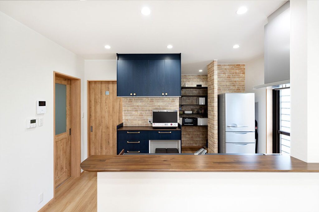 リビング側から見たキッチン。手元が見えない腰壁仕様です。>