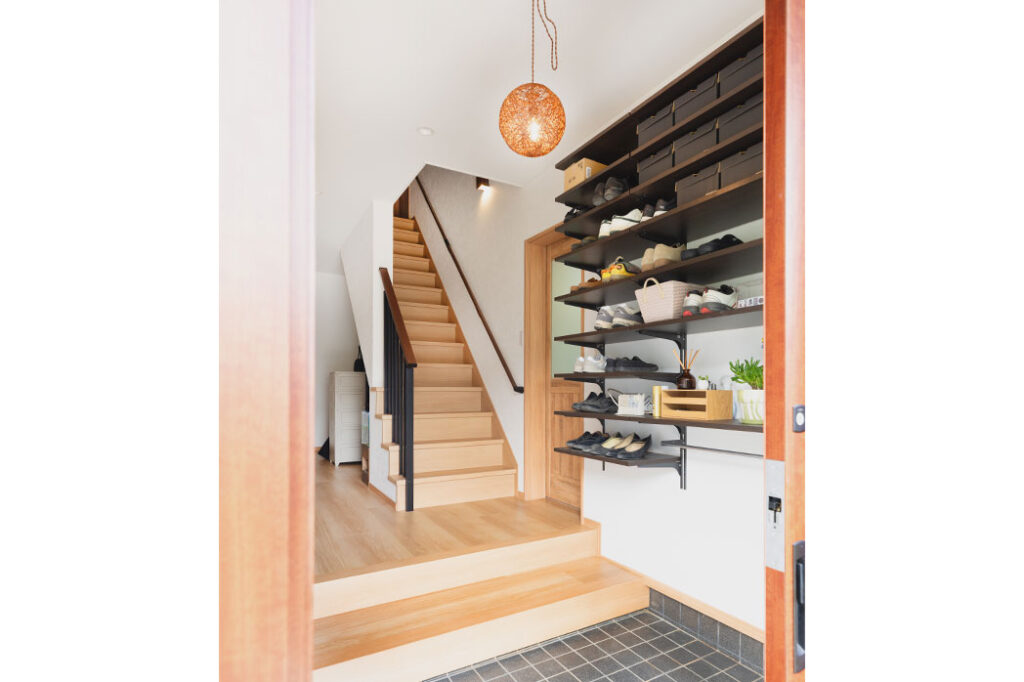 2世帯共通の玄関ホール。大きな靴を収納できるように収納棚はオープンにしました。>