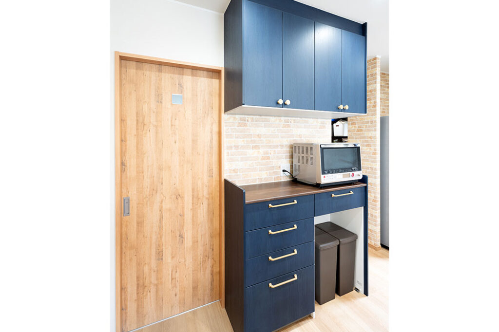 キッチン背面の収納スペース。手前の扉は洗面所、奥にはパントリーにつながっています。>