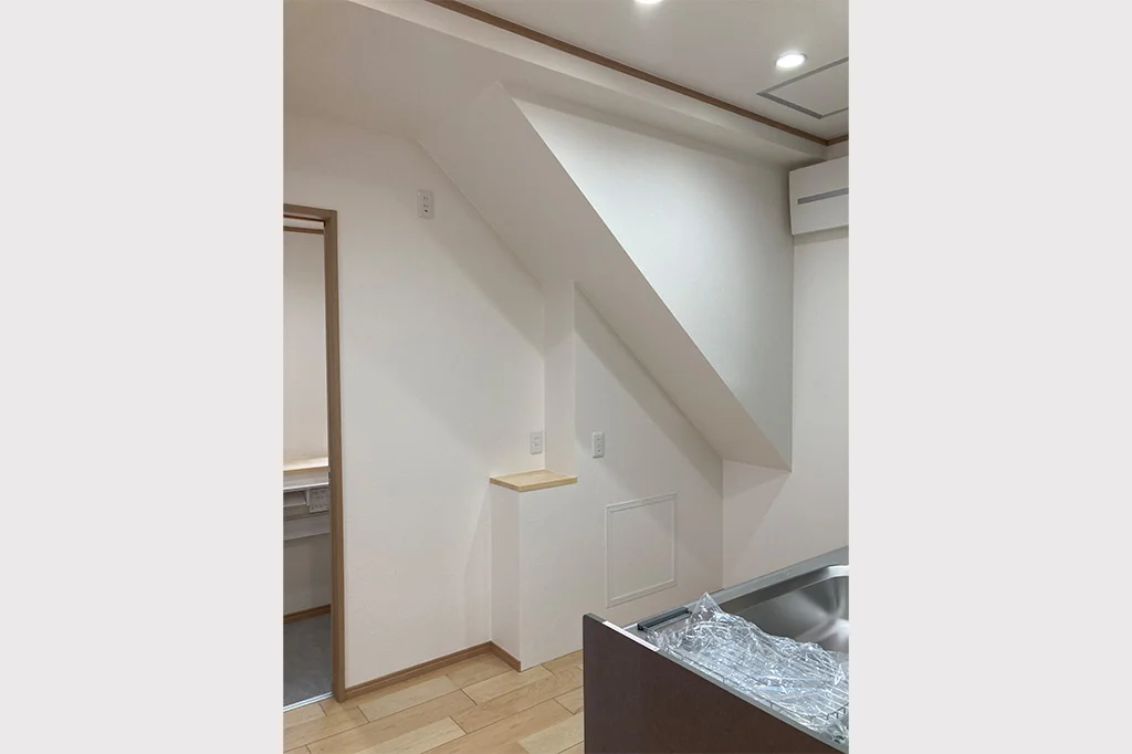 キッチン奥は階段下スペースとなりましたが、冷蔵庫や収納棚が置ける広さを確保しました。>