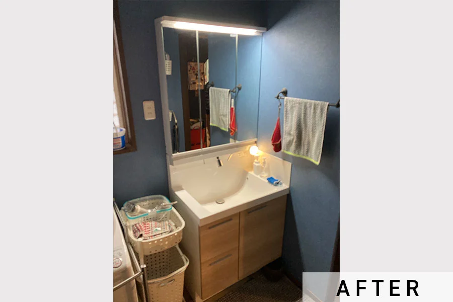 施工後の洗面台。明るい木目調の扉です。>